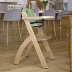 Happy baby is sitting in the Abiie Beyond Junior High Chair